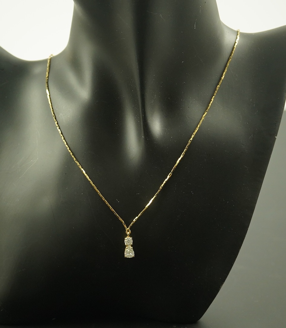 A modern gold and two stone diamond pendant